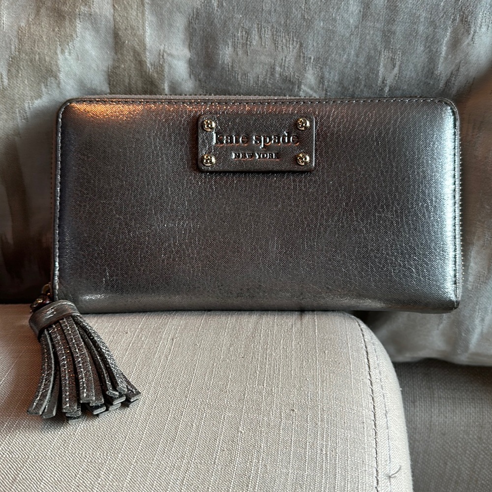 Silver metallic Kate Spade zip around wallet with gold zipper and accents